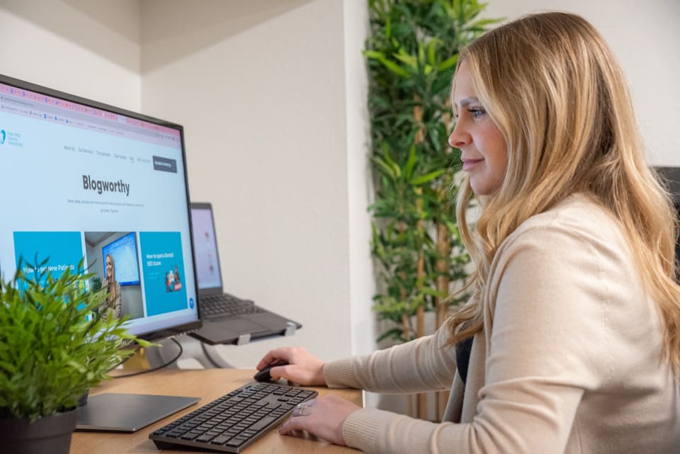 A practice team member reviewing a dental marketing website on a desktop screen